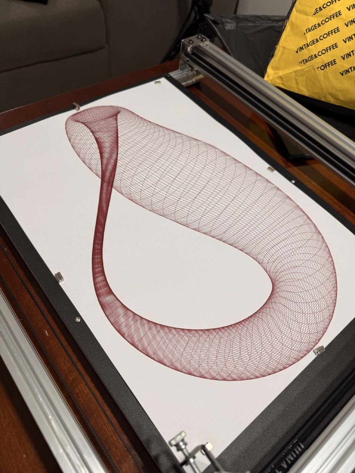 Wireframe 3D horn shape in dark red ink.